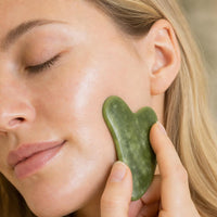 Primer plano piedra gua sha en contacto con la piel