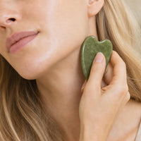 Primer plano piedra gua sha en el cuello