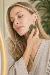 Modelo usando la piedra gua sha Tazorix en el rostro
