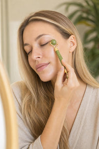 Mujer usando el rodillo de jade en el contorno de ojos